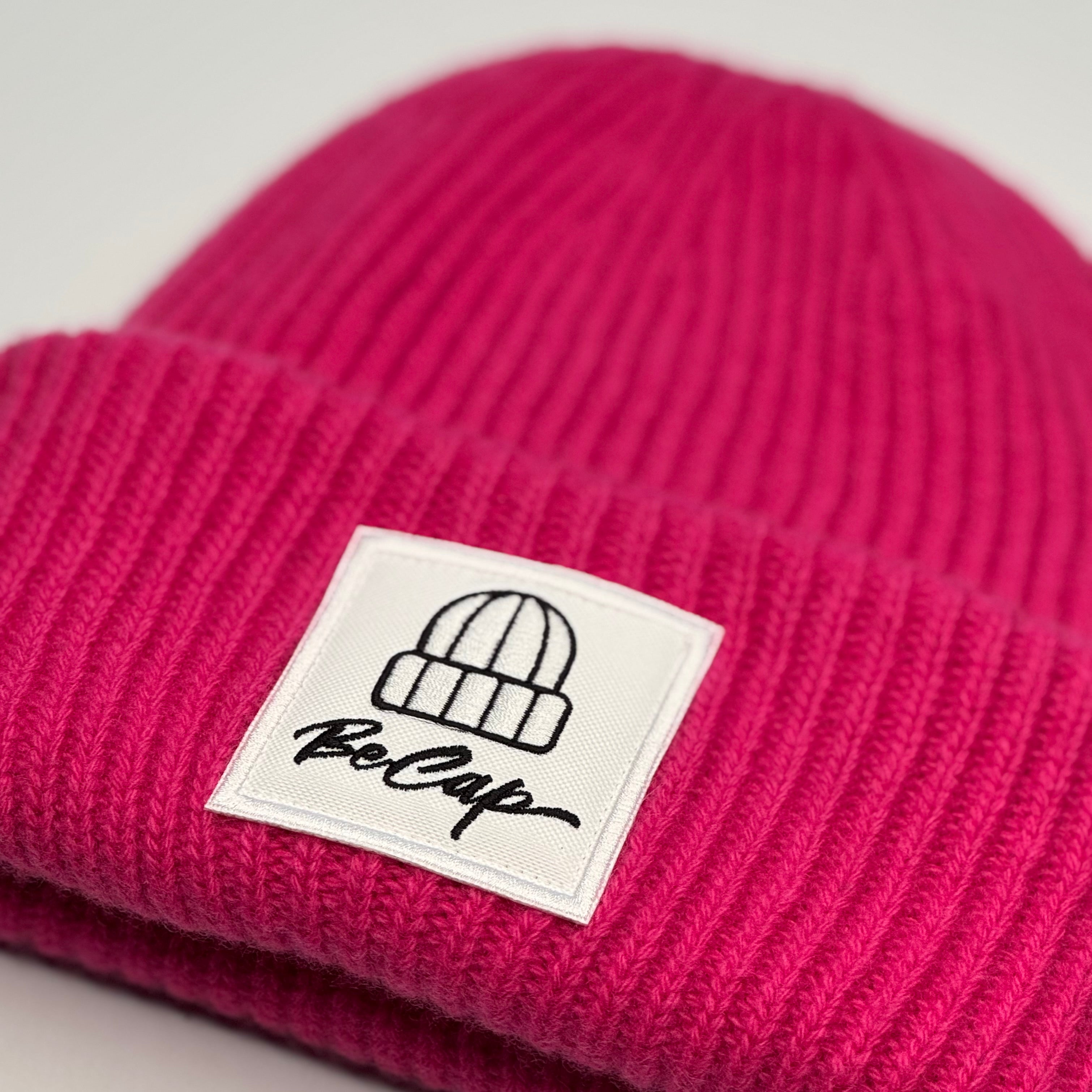 Cuffia lana merino unisex color lampone con logo BeCap su risvolto alto.