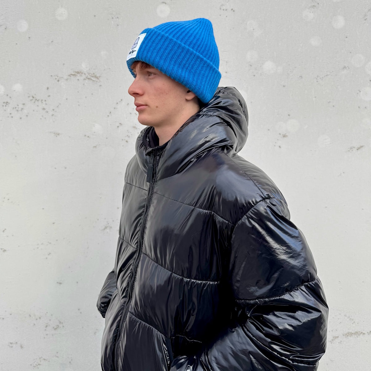 CUFFIA OVER 100% LANA MERINO LOGO BECAP FIORDALISO indossata con piumino nero